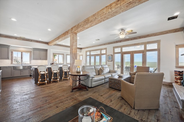 living room with french doors, beamed ceiling, dark wood-type flooring, decorative columns, and ceiling fan