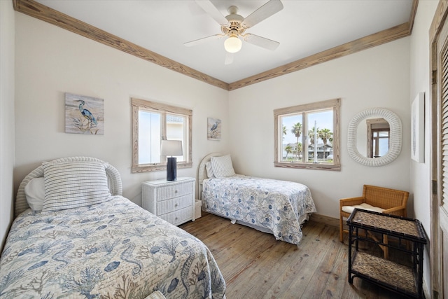 bedroom featuring crown molding, hardwood / wood-style flooring, and ceiling fan