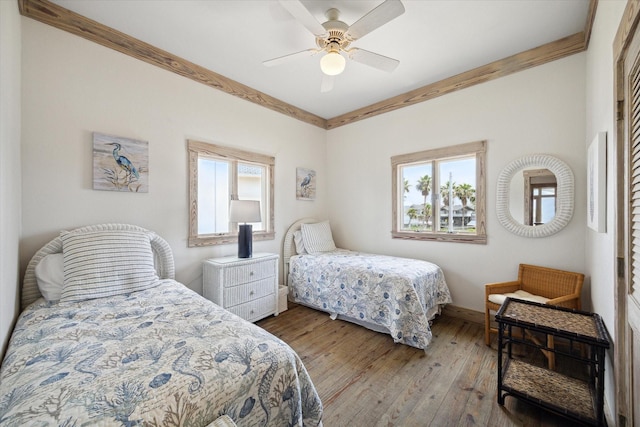 bedroom with hardwood / wood-style floors, baseboards, and ceiling fan