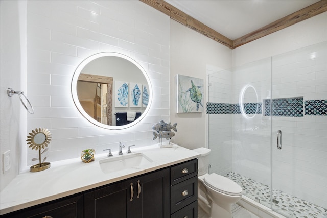 bathroom with vanity, toilet, backsplash, and a shower with door