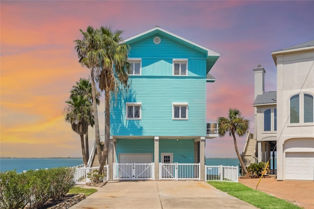 view of front of house with a garage and a water view