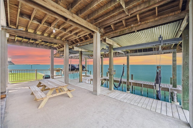 view of patio featuring boat lift, a boat dock, and a water view