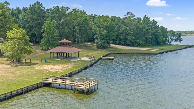 dock area featuring a water view, a lawn, and a gazebo