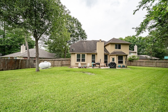 rear view of property featuring a lawn and a patio