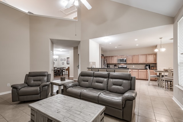 tiled living room with ceiling fan with notable chandelier, high vaulted ceiling, and a healthy amount of sunlight