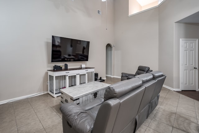 tiled living room featuring a towering ceiling