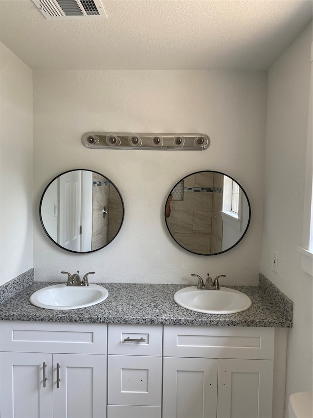 bathroom with a textured ceiling and vanity