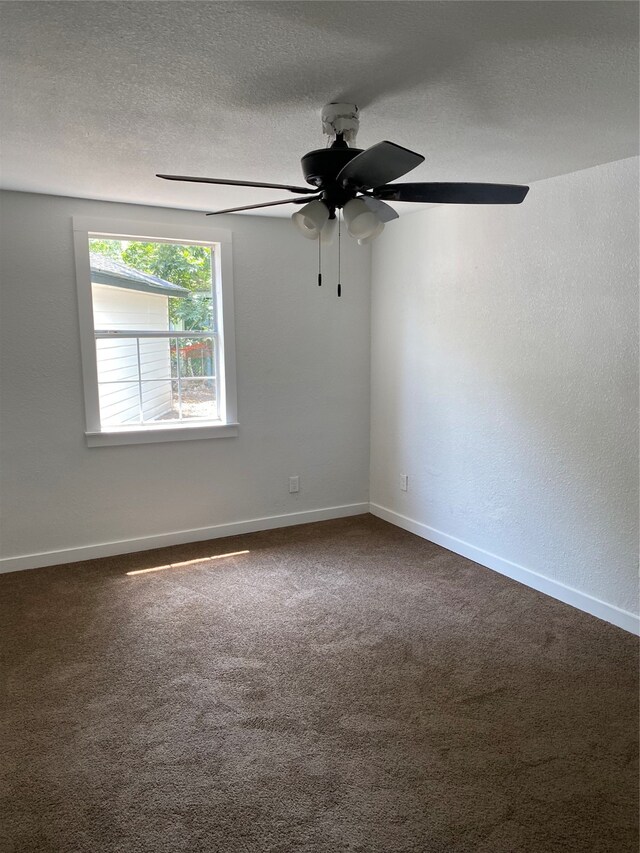 carpeted spare room featuring ceiling fan and a textured ceiling