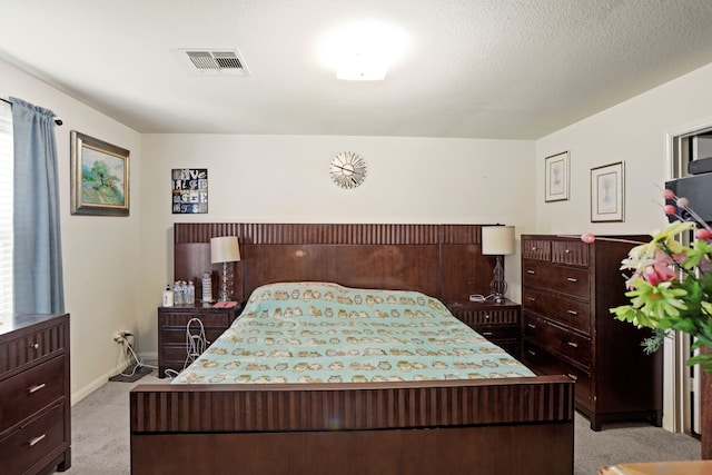 bedroom featuring light colored carpet and a textured ceiling