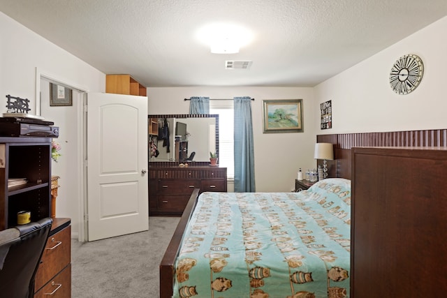 carpeted bedroom featuring a textured ceiling