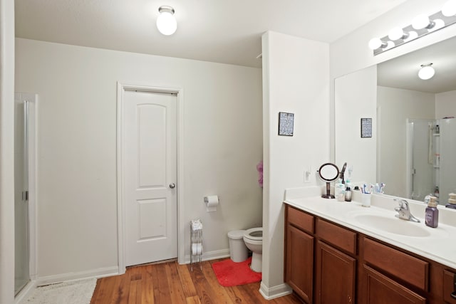 bathroom with a shower with door, toilet, hardwood / wood-style flooring, and vanity