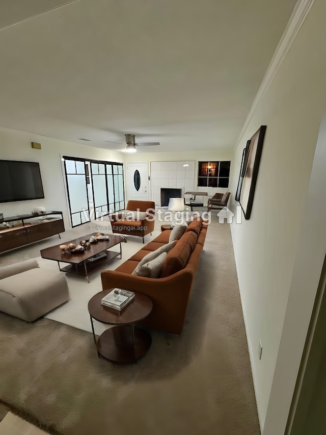 living room with ceiling fan, crown molding, and a fireplace