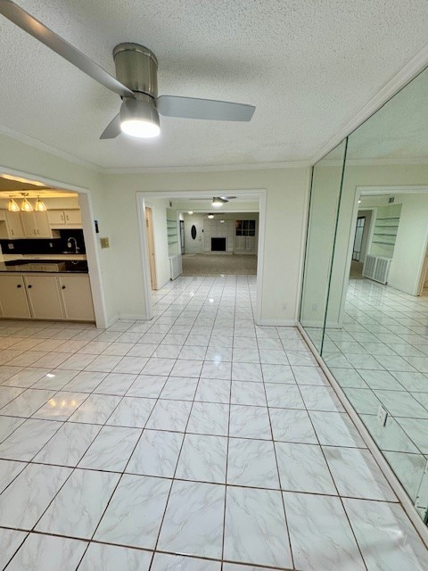 hallway featuring light tile patterned floors, crown molding, and a textured ceiling