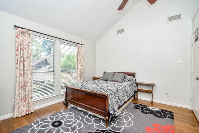 bedroom with ceiling fan, high vaulted ceiling, and wood-type flooring