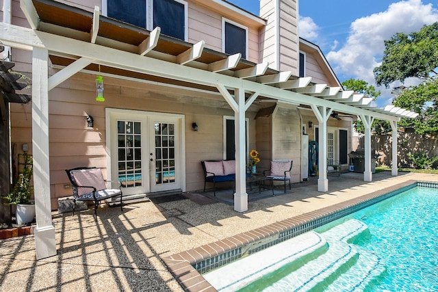 rear view of property with a pergola, a patio area, and french doors