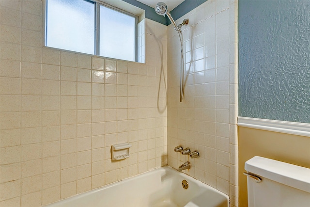 bathroom featuring toilet and tiled shower / bath combo