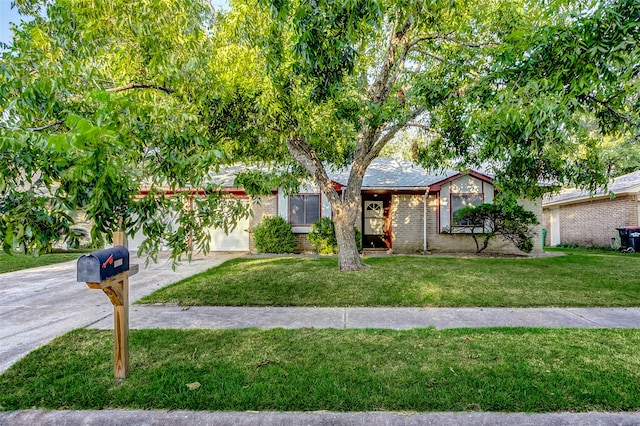 single story home with an attached garage, a front lawn, concrete driveway, and brick siding