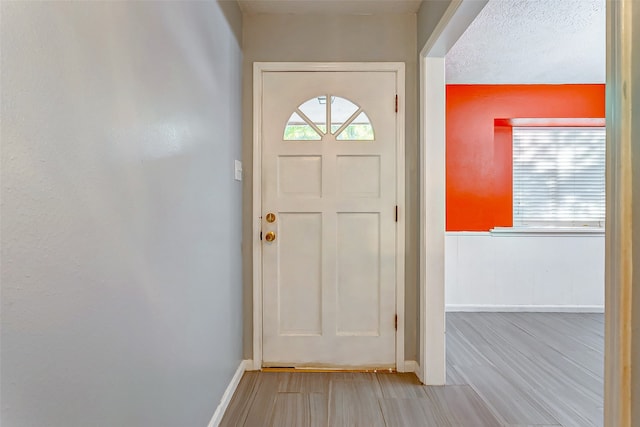 doorway to outside featuring a textured ceiling and hardwood / wood-style floors