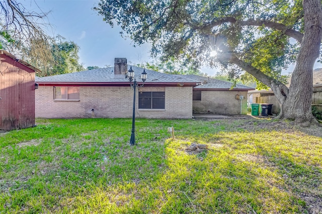 rear view of house featuring a yard