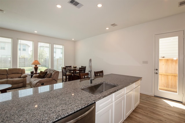 kitchen featuring white cabinetry, sink, light wood-type flooring, and dark stone counters