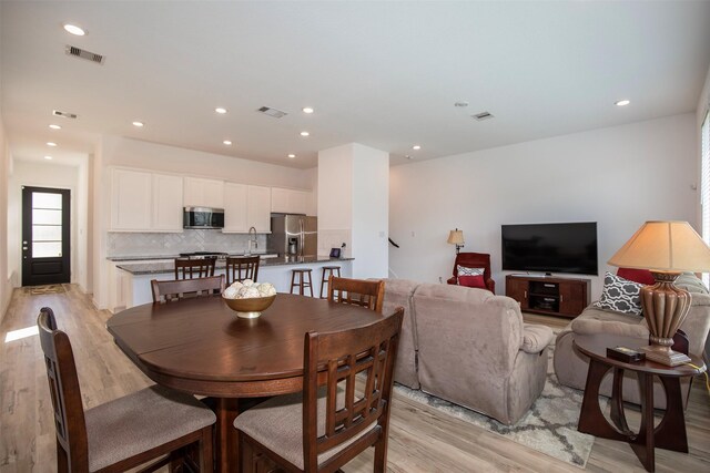 dining space with light hardwood / wood-style flooring and sink