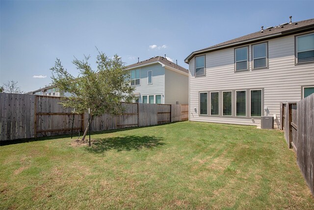 back of property featuring a lawn and central AC