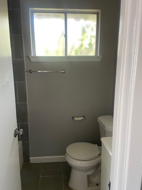 bathroom with toilet, vanity, and tile patterned floors