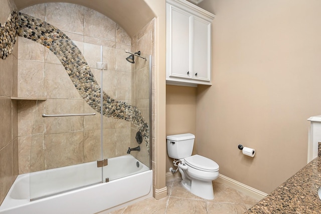 bathroom featuring toilet, baseboards, and shower / bath combination with glass door