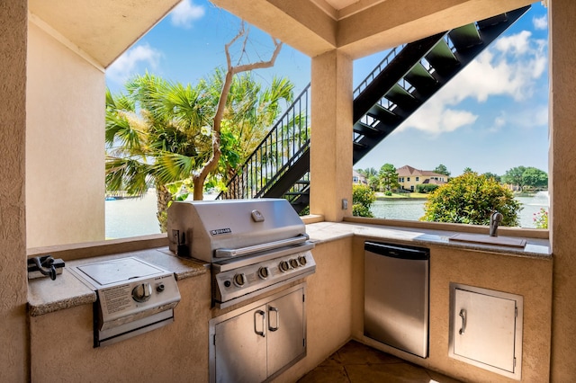 view of patio featuring area for grilling, a grill, a water view, and a sink