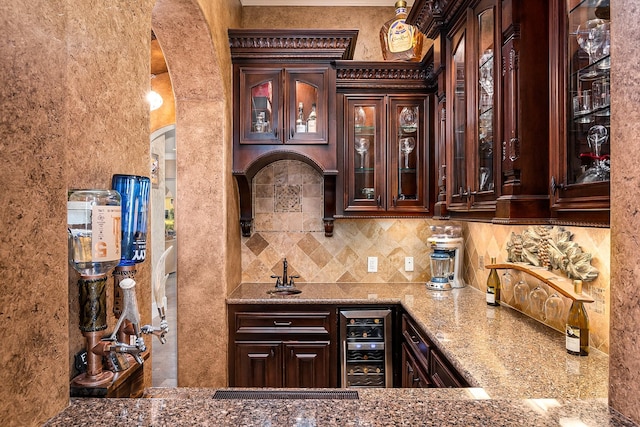 bar featuring indoor wet bar, arched walkways, beverage cooler, and decorative backsplash