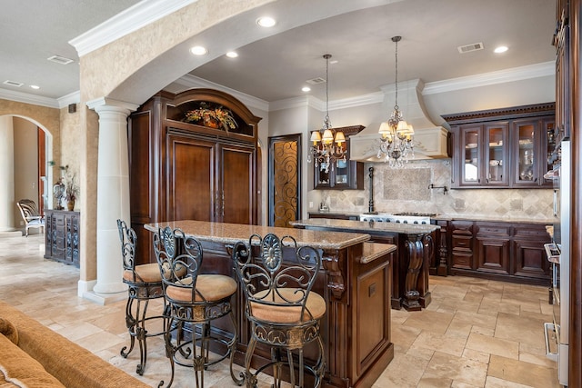 bar featuring visible vents, ornamental molding, tasteful backsplash, stone tile flooring, and arched walkways