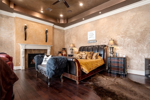 bedroom featuring visible vents, a raised ceiling, crown molding, and hardwood / wood-style flooring