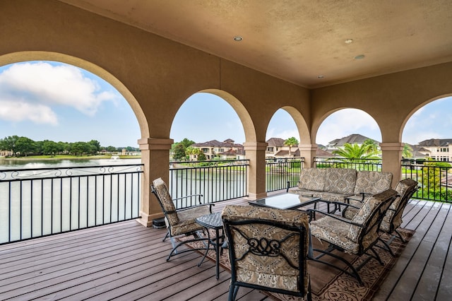 deck with outdoor lounge area and a water view