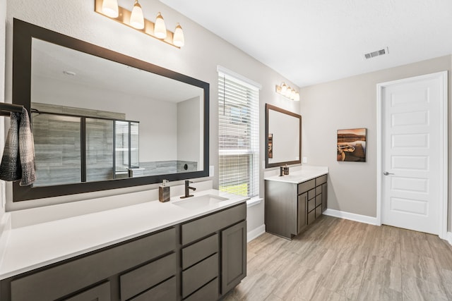 bathroom featuring hardwood / wood-style floors, vanity, and a shower with shower door