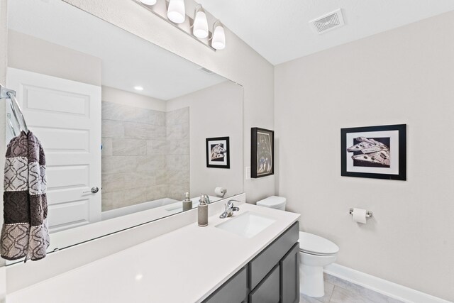 bathroom featuring toilet, vanity, and tile patterned floors