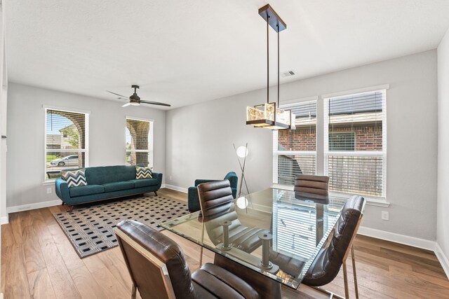 dining area with visible vents, baseboards, a ceiling fan, and wood-type flooring