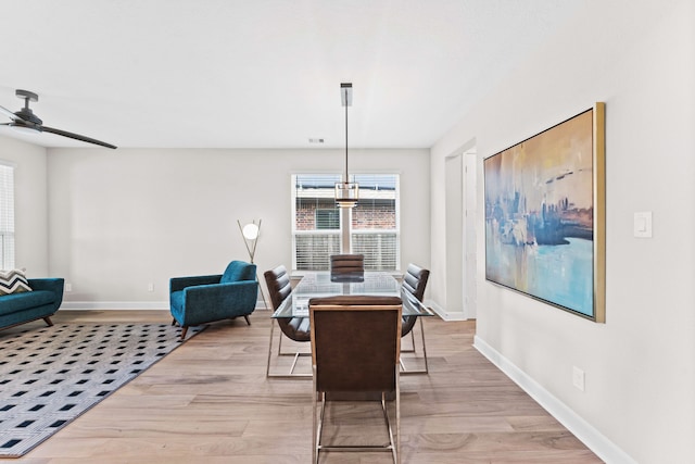 dining area with light hardwood / wood-style flooring and ceiling fan