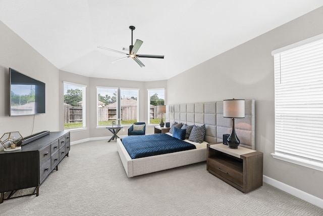 bedroom featuring a ceiling fan, lofted ceiling, light colored carpet, and baseboards