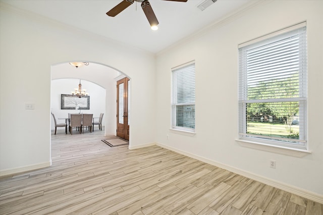 spare room with ceiling fan with notable chandelier, light wood-type flooring, plenty of natural light, and crown molding