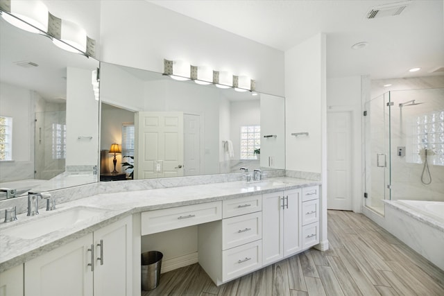 bathroom featuring hardwood / wood-style flooring, plenty of natural light, shower with separate bathtub, and vanity