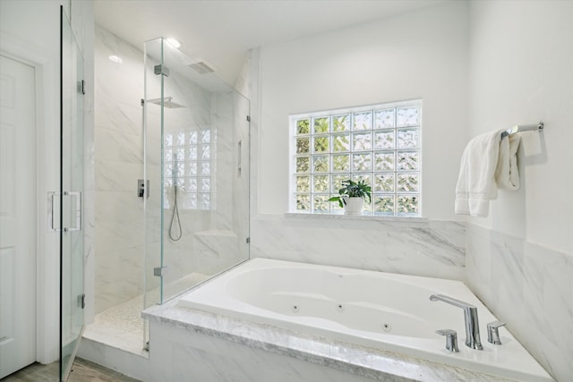 bathroom featuring shower with separate bathtub