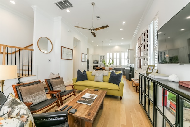 living room featuring light wood-type flooring, ceiling fan, and crown molding