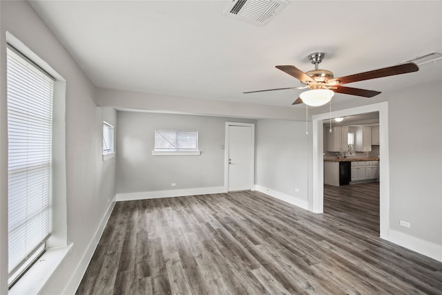 spare room with dark wood-type flooring and ceiling fan