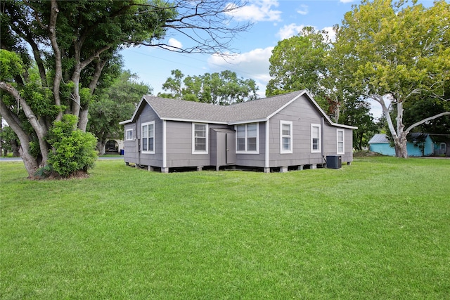 exterior space featuring cooling unit and a front lawn