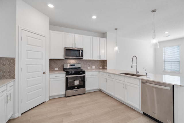 kitchen with white cabinetry, sink, pendant lighting, and appliances with stainless steel finishes