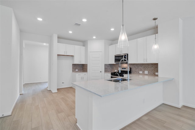 kitchen with white cabinetry, light wood-type flooring, appliances with stainless steel finishes, and decorative light fixtures