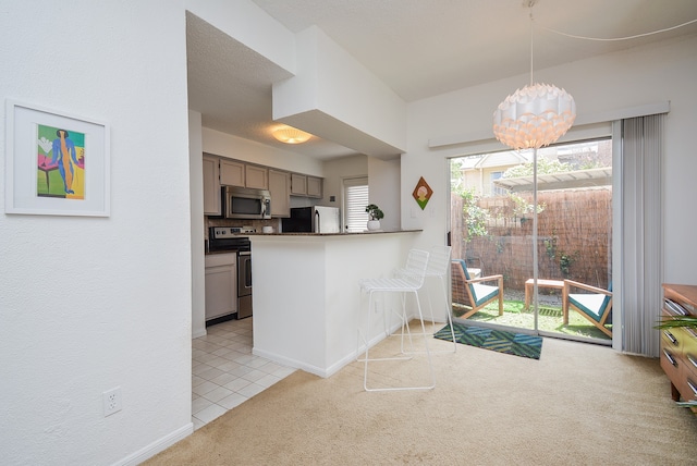 kitchen featuring backsplash, a notable chandelier, appliances with stainless steel finishes, light carpet, and kitchen peninsula