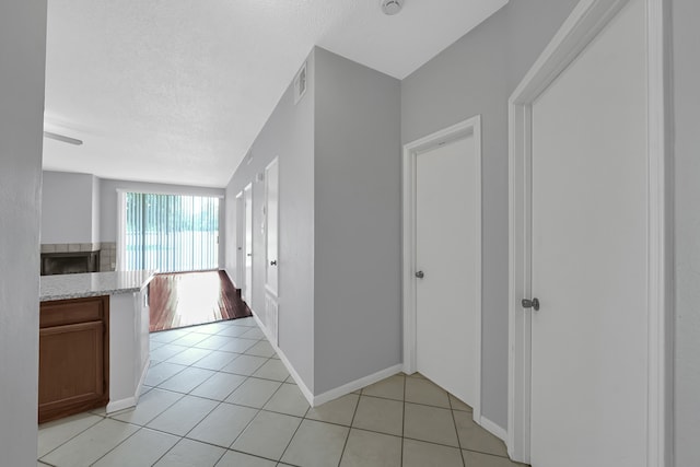 hall with a textured ceiling and light hardwood / wood-style floors