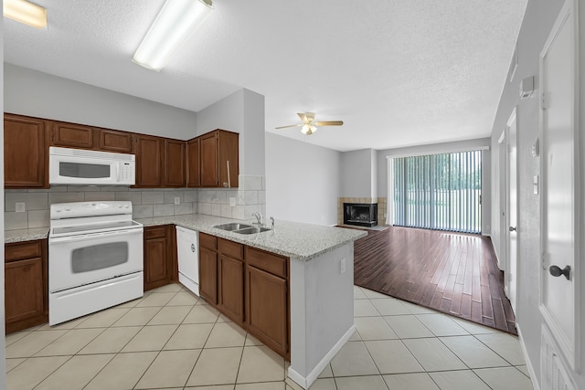 kitchen featuring ceiling fan, sink, kitchen peninsula, light tile patterned flooring, and white appliances