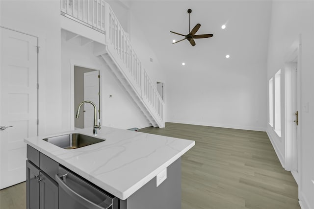 kitchen with sink, stainless steel dishwasher, a center island with sink, and light hardwood / wood-style flooring